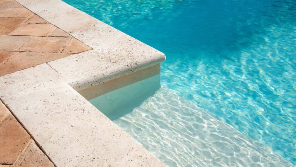 Dépôts de calcaire blanc visibles sur les parois d'une piscine avec liner bleu