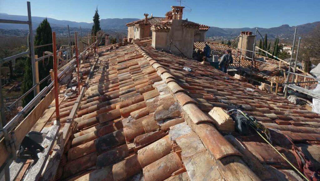 Chantier de réfection de toiture sur une maison provençale avec tuiles terre cuite et équipement de sécurité